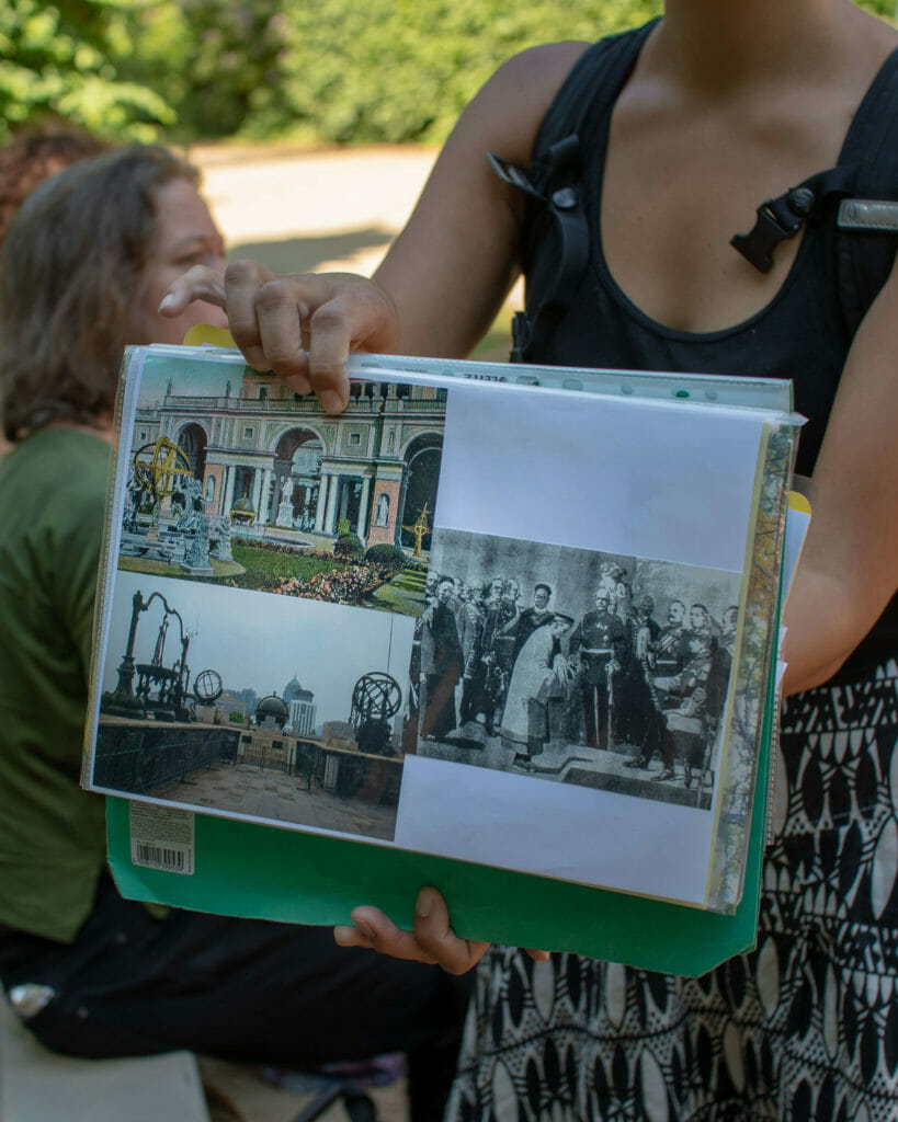 Anna von Postcolonial Potsdam zeigt uns Bilder von den astronomischen Instrumenten, die vor dem Orangerieschloss standen.